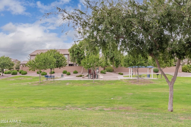 view of property's community with a playground and a yard