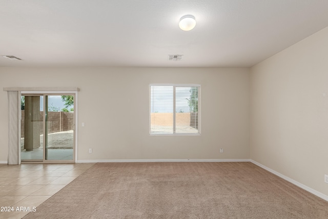 spare room featuring light carpet