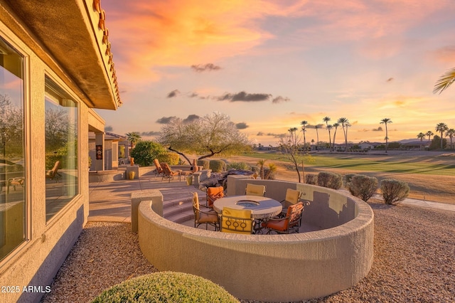 patio terrace at dusk featuring an outdoor fire pit