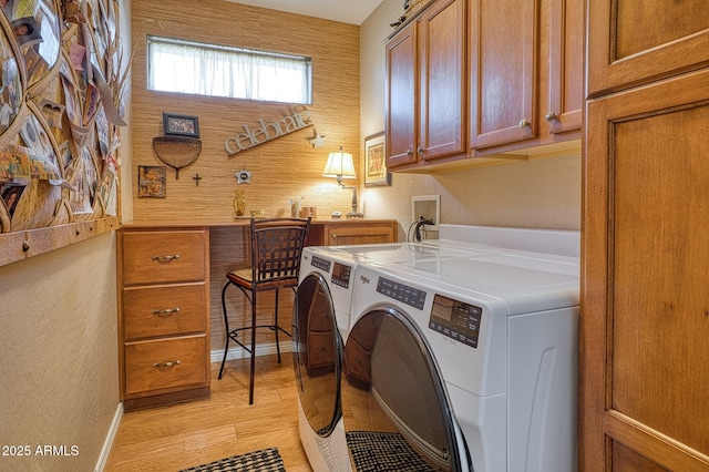 washroom featuring cabinets, washer and clothes dryer, and light wood-type flooring