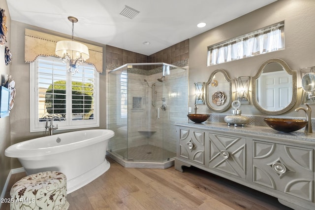 bathroom featuring an inviting chandelier, vanity, separate shower and tub, and wood-type flooring