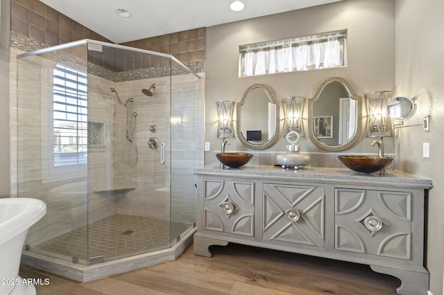 bathroom with hardwood / wood-style flooring, lofted ceiling, vanity, and a shower with shower door