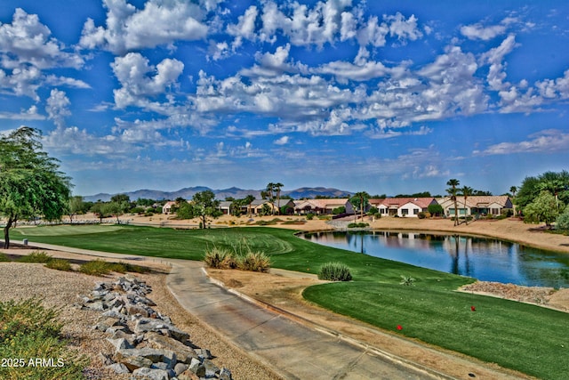 view of home's community with a water and mountain view and a lawn