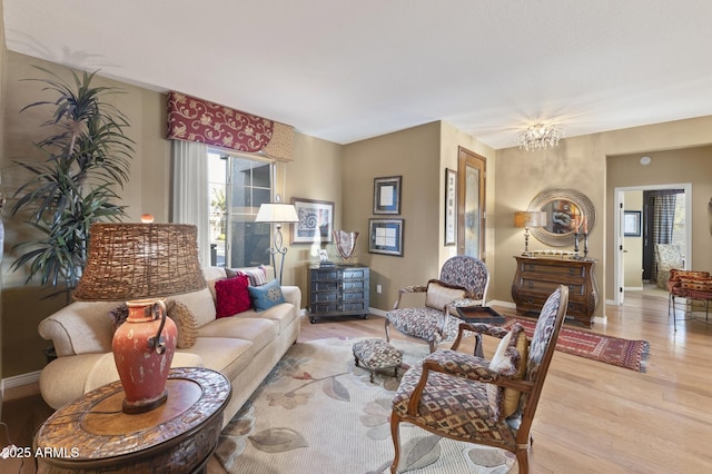 living room featuring an inviting chandelier and light wood-type flooring