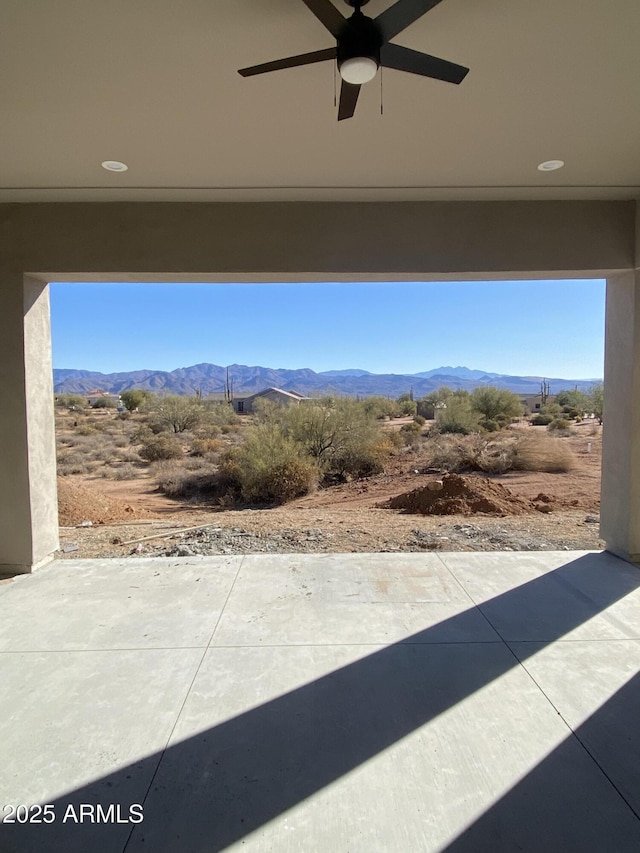 view of patio featuring ceiling fan and a mountain view