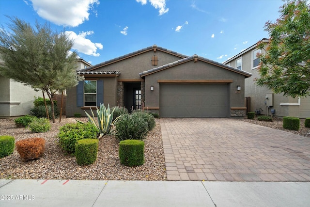 11623 W Marguerite Ave, Avondale, AZ 85323 - view of front of property with stone siding, stucco siding, an attached garage, a tiled roof, and decorative driveway