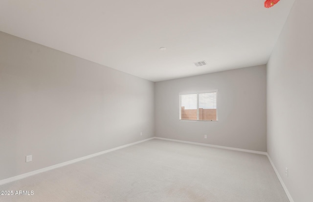 spare room with light carpet, visible vents, and baseboards