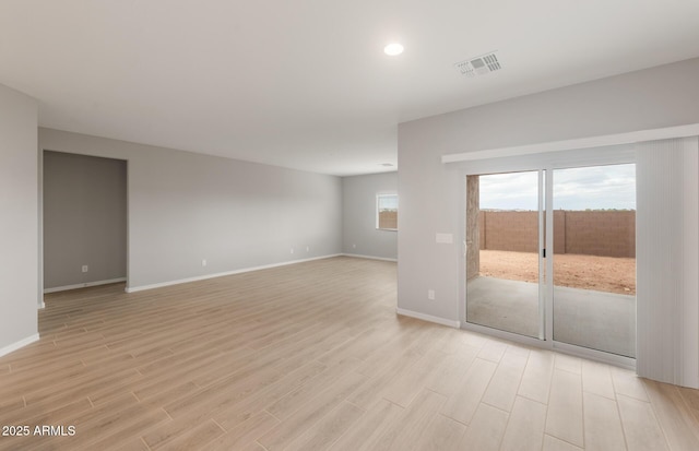 unfurnished room featuring recessed lighting, light wood-type flooring, visible vents, and baseboards