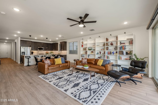 living room featuring ceiling fan and light hardwood / wood-style floors