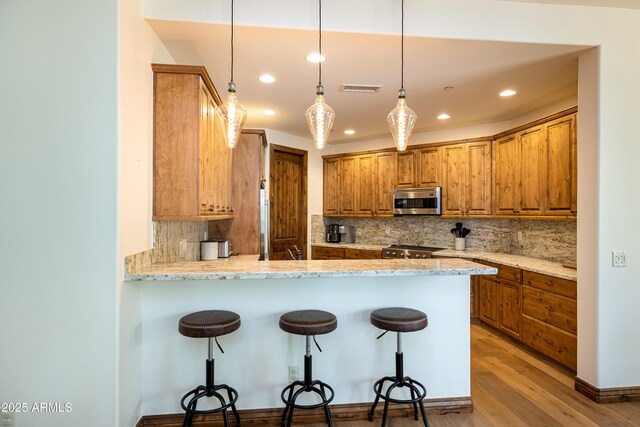 1734 E Mossy Oak Ct Unit 2, Flagstaff, AZ 86005 - kitchen with a breakfast bar, tasteful backsplash, visible vents, and stainless steel microwave