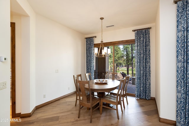 1734 E Mossy Oak Ct Unit 2, Flagstaff, AZ 86005 - dining space with a chandelier, baseboards, visible vents, and wood finished floors