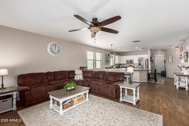 living room featuring wood-type flooring and ceiling fan