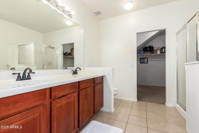 bathroom with tile patterned flooring, vanity, toilet, and a shower with shower door