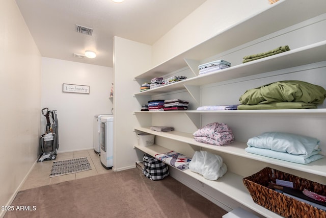 laundry area featuring light tile patterned flooring and washer and clothes dryer