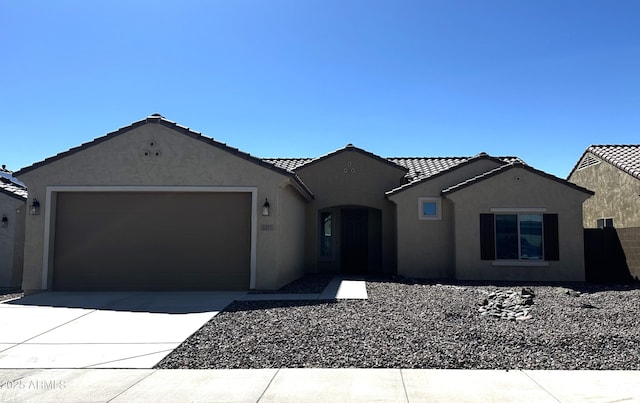 ranch-style house featuring a garage, concrete driveway, a tiled roof, and stucco siding