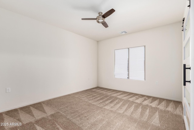 6331 W Desert Blossom Way, Florence, AZ 85132 - carpeted empty room with a ceiling fan, a barn door, and baseboards
