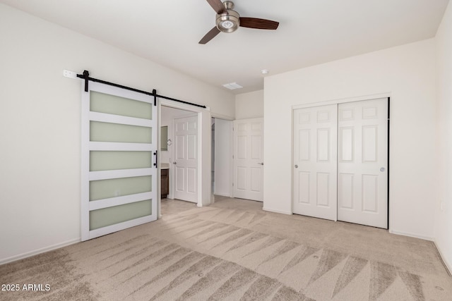6331 W Desert Blossom Way, Florence, AZ 85132 - unfurnished bedroom featuring carpet flooring, a barn door, a closet, and baseboards