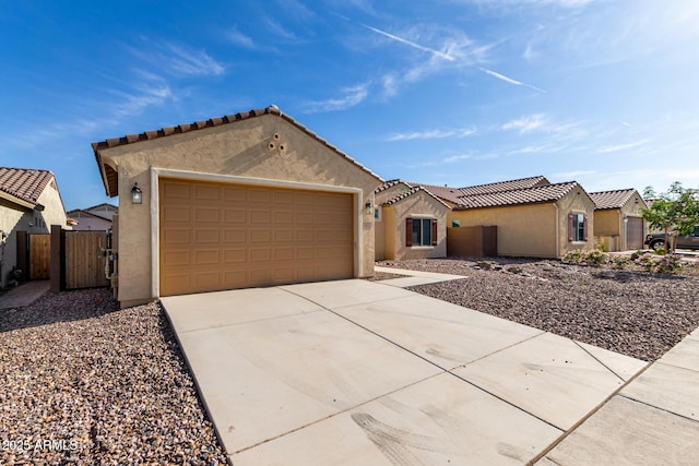 6331 W Desert Blossom Way, Florence, AZ 85132 - mediterranean / spanish home featuring stucco siding, concrete driveway, an attached garage, a tiled roof, and a gate