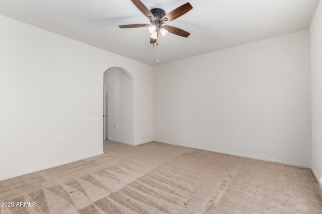 6331 W Desert Blossom Way, Florence, AZ 85132 - empty room featuring arched walkways, light carpet, a ceiling fan, and baseboards