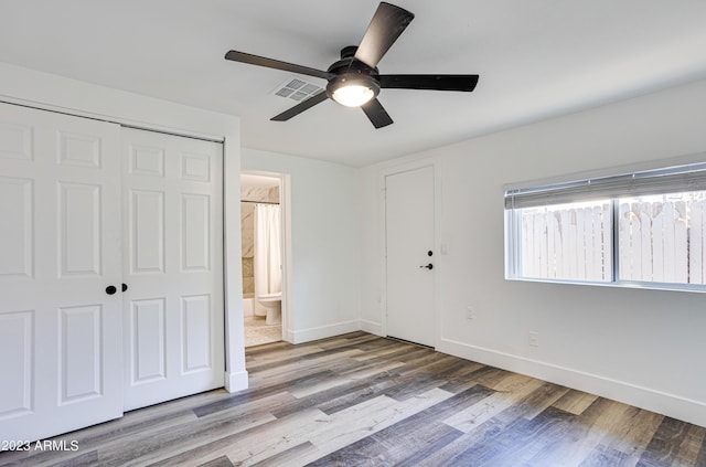 unfurnished bedroom with visible vents, baseboards, a ceiling fan, wood finished floors, and a closet