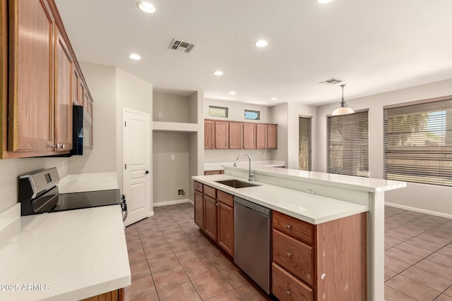 17419 W Elaine Dr, Goodyear, AZ 85338 - kitchen with stainless steel appliances, light tile patterned floors, recessed lighting, light countertops, and brown cabinetry