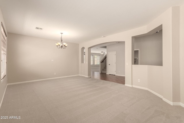 17419 W Elaine Dr, Goodyear, AZ 85338 - carpeted empty room featuring arched walkways, a chandelier, and stairs
