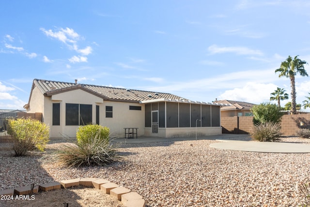 rear view of house with a patio area and a sunroom