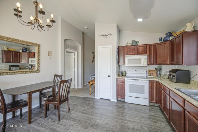 23993 N Desert Dr, Florence, AZ 85132 - kitchen featuring white appliances, arched walkways, dark wood-style floors, light countertops, and lofted ceiling
