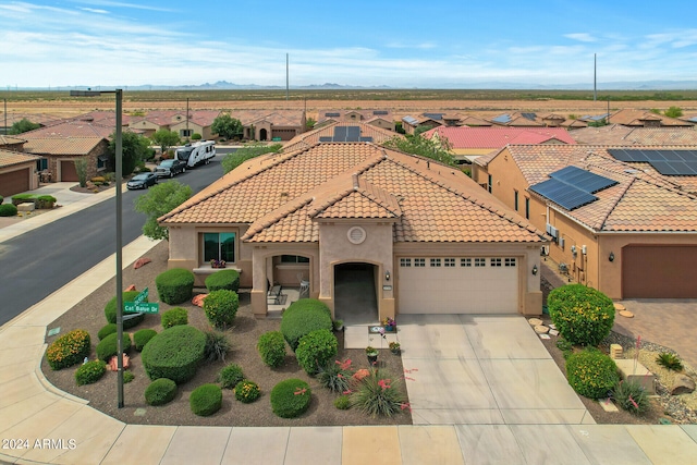 mediterranean / spanish-style house featuring solar panels and a garage