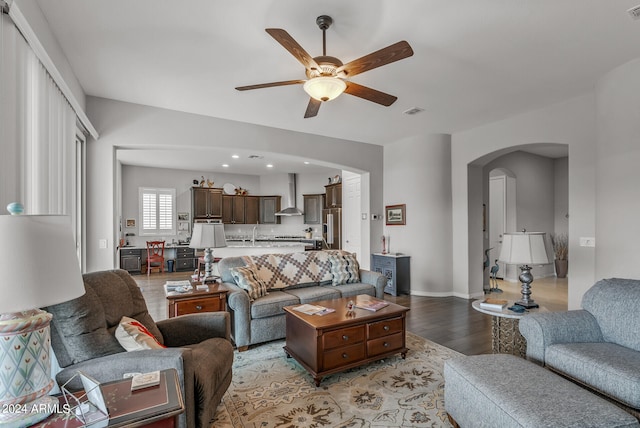 living room featuring sink, light hardwood / wood-style flooring, and ceiling fan