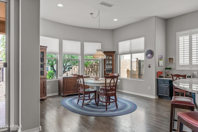 dining space featuring a healthy amount of sunlight and dark hardwood / wood-style flooring