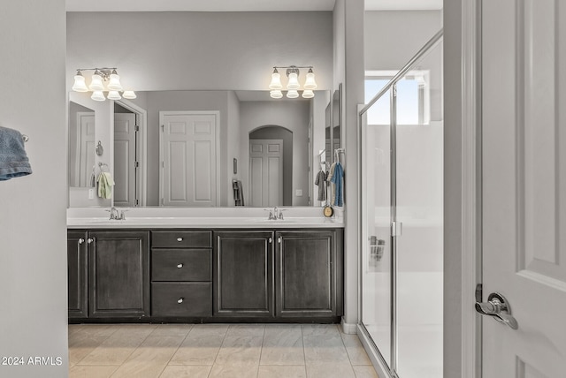 bathroom featuring walk in shower, dual vanity, and tile flooring