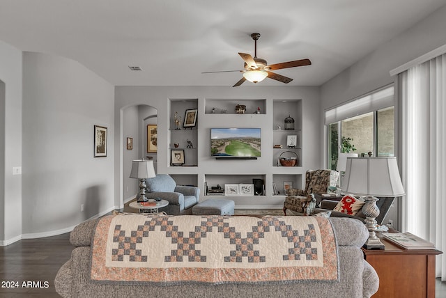 living room with wood-type flooring, ceiling fan, and built in shelves