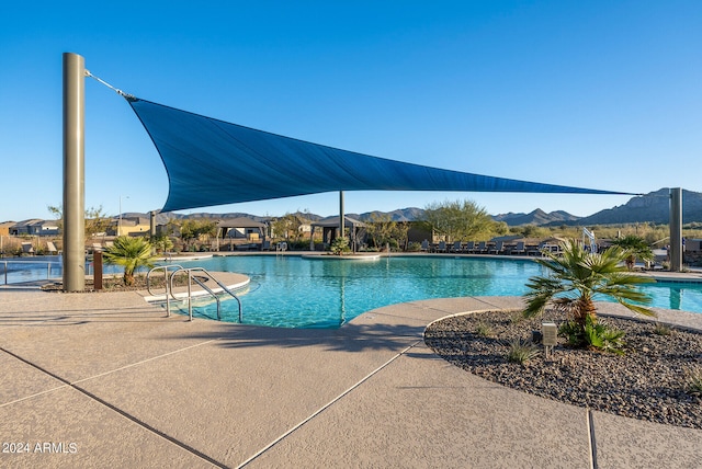 view of swimming pool with a patio and a mountain view