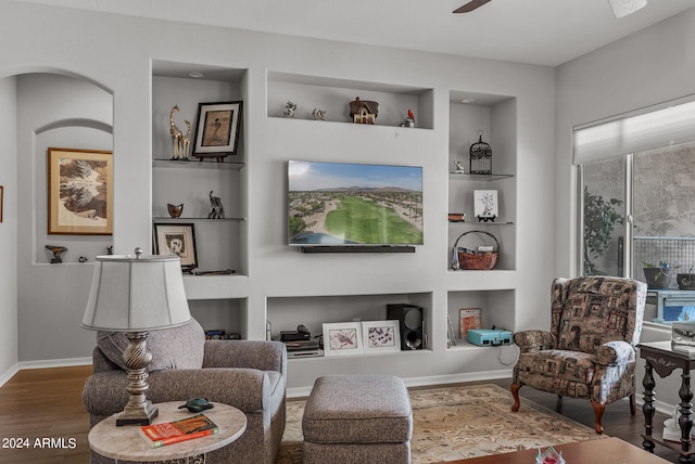 sitting room featuring wood-type flooring, ceiling fan, and built in features