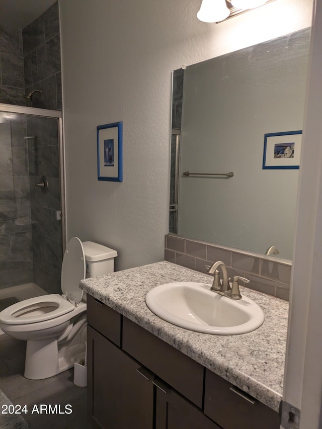 bathroom featuring vanity, toilet, and tiled shower