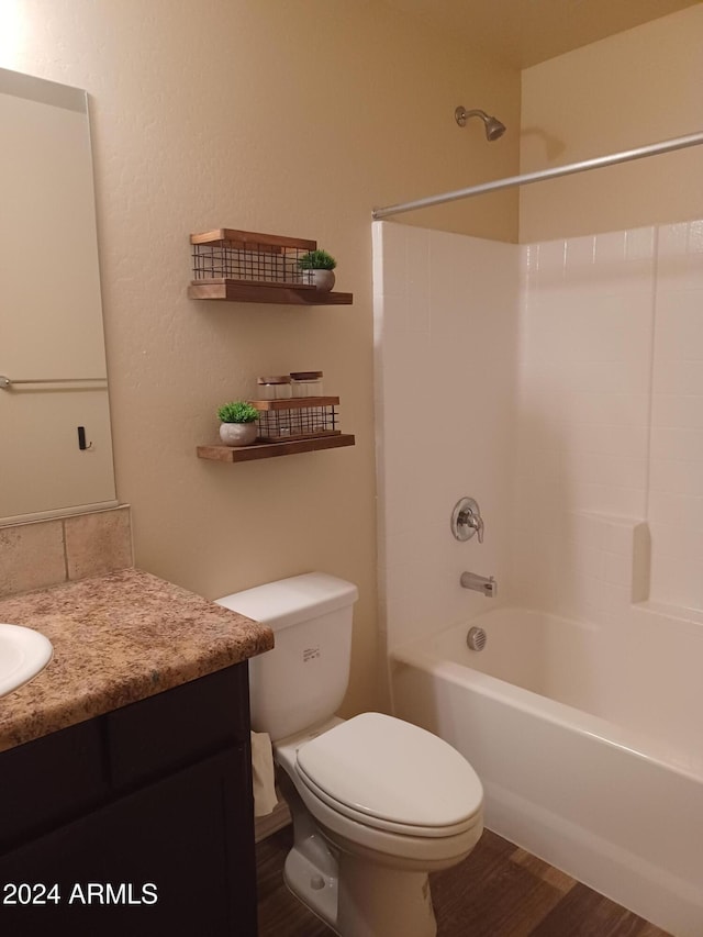 full bathroom with washtub / shower combination, toilet, vanity, and hardwood / wood-style flooring