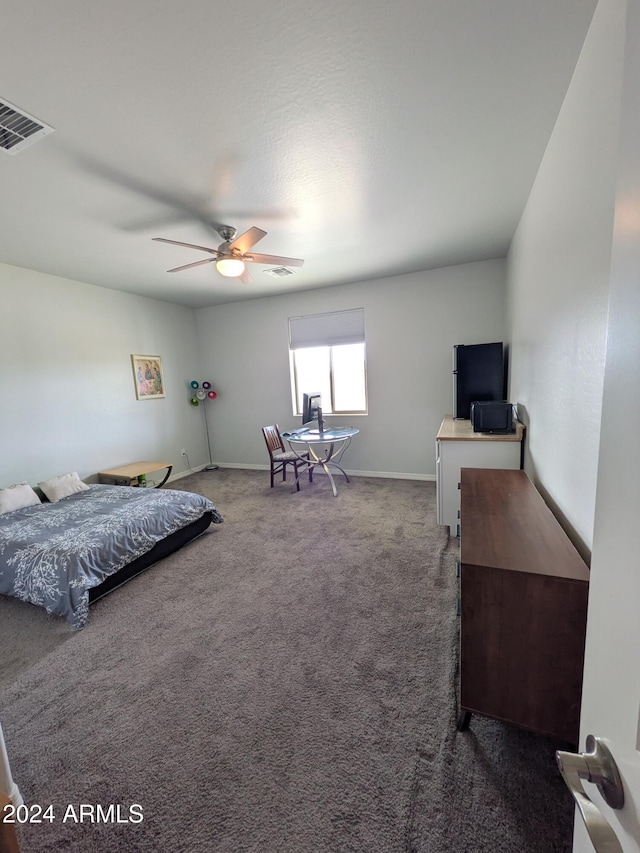 bedroom featuring ceiling fan and dark carpet