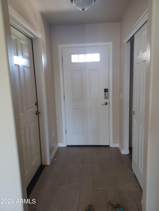 entryway with dark tile patterned flooring