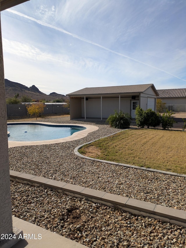 view of swimming pool with a lawn and a mountain view