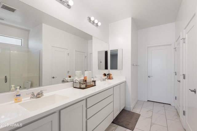 bathroom with vanity and a shower with door