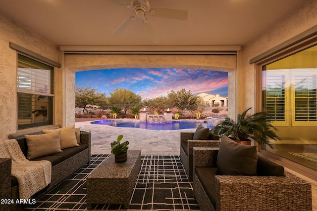 patio terrace at dusk with ceiling fan and an outdoor living space