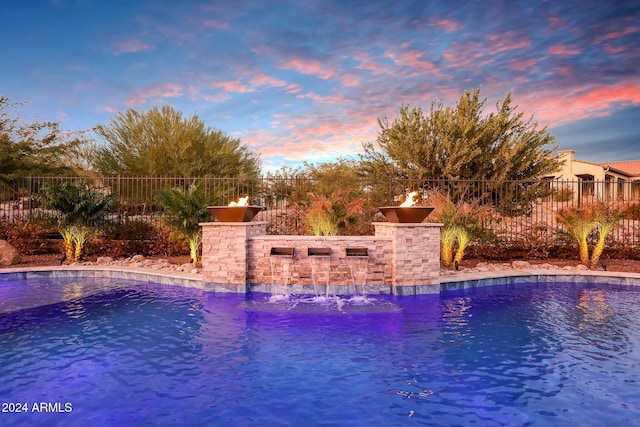 pool at dusk with pool water feature