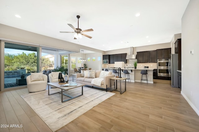 living room with ceiling fan and light wood-type flooring