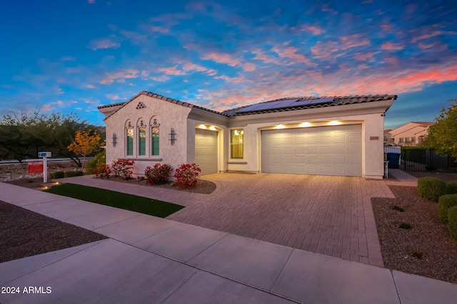 mediterranean / spanish-style home with a garage and solar panels