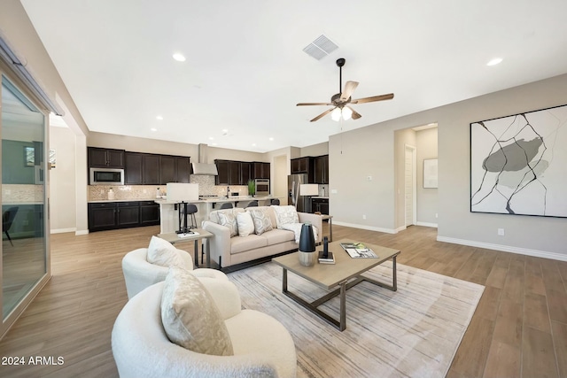 living room featuring ceiling fan and light hardwood / wood-style flooring