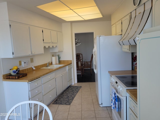 kitchen featuring white cabinetry, sink, white appliances, and light tile patterned floors