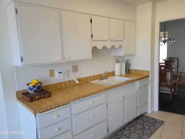 kitchen with sink, white cabinetry, a chandelier, light tile patterned floors, and white dishwasher