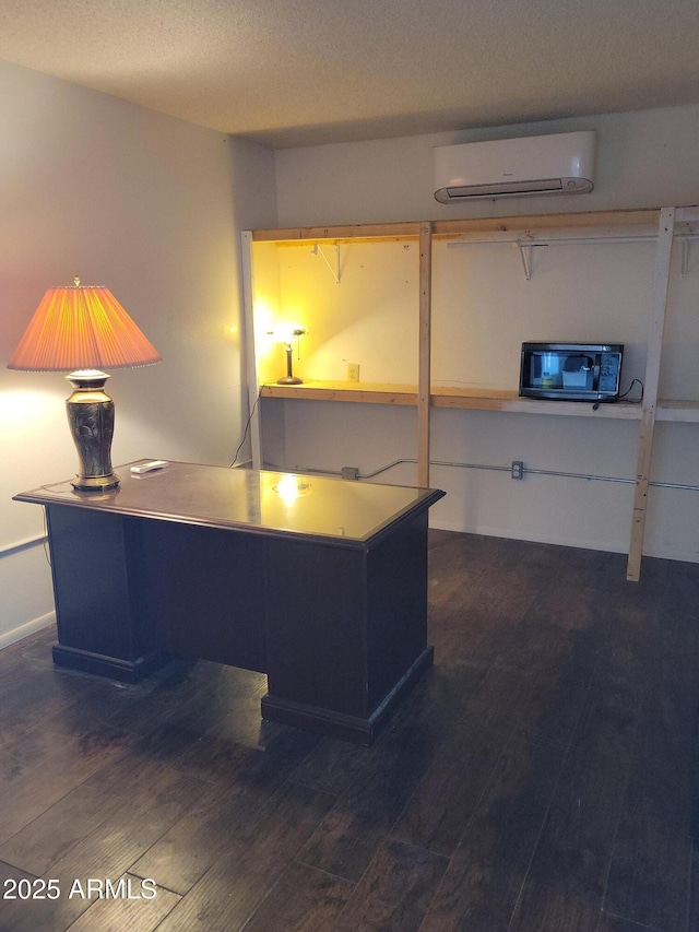 home office featuring dark hardwood / wood-style flooring, a textured ceiling, and a wall mounted AC