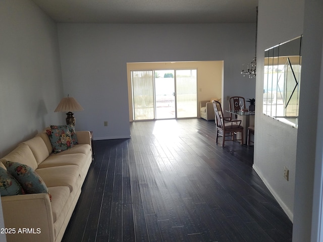 living room with dark hardwood / wood-style floors, a healthy amount of sunlight, and an inviting chandelier